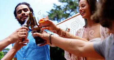 一群快乐的朋友在户外烧烤聚会上品尝饮料